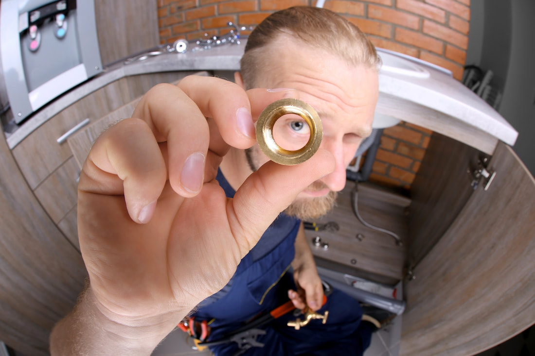 Plumber looking through pipe fitting