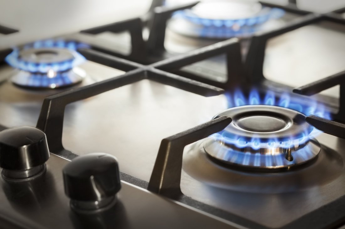 Image of lit gas cooker hob showing blue flames