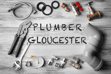 Image of the word plumber in the centre and different plumbing tools scattered around it.